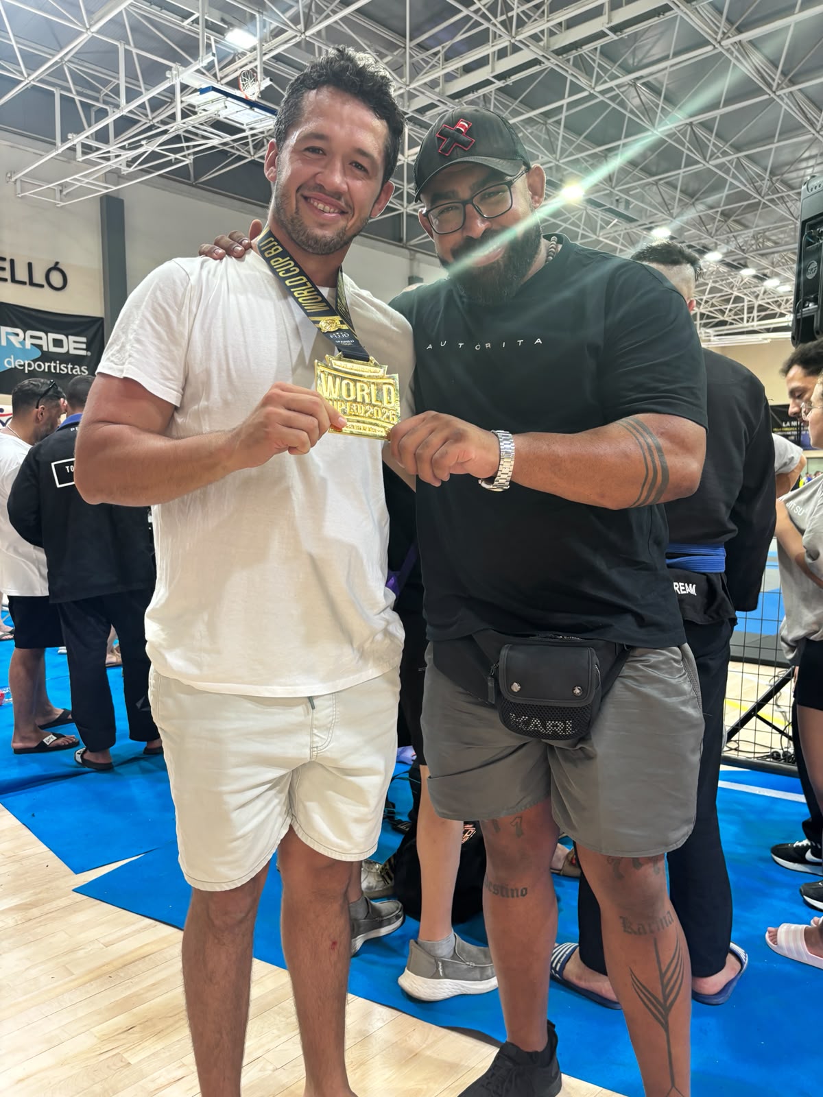 El deportista Jus Lauren muestra su medalla de oro de Jiu Jitsu junto al fisioterapeuta de SOMA